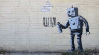 Taiteilija Banksyn newyorkilaiseen seinään piirtämä robotti.